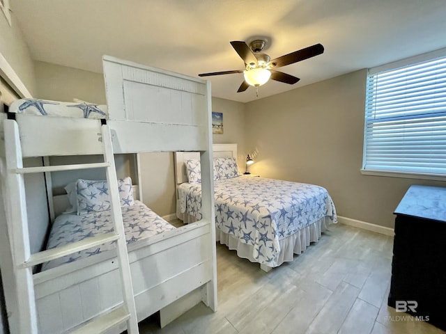 bedroom with ceiling fan, wood finished floors, and baseboards