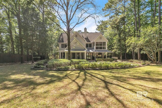 1106 Old County Rd, Daphne, AL 36526 - rear view of house featuring a lawn, a sunroom, fence, and a chimney