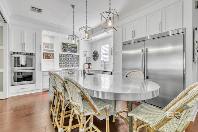 1106 Old County Rd, Daphne, AL 36526 - kitchen with decorative backsplash, visible vents, white cabinets, stainless steel appliances, and hardwood / wood-style floors