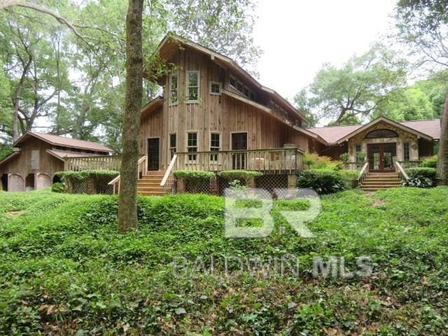 rustic home with a deck and french doors