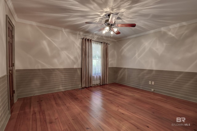 empty room featuring crown molding, hardwood / wood-style flooring, and ceiling fan