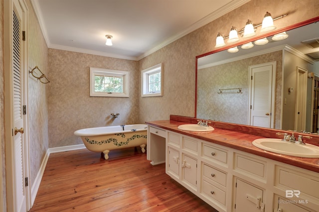 bathroom with ornamental molding, a bath, and hardwood / wood-style floors