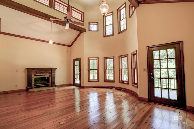 unfurnished living room featuring light hardwood / wood-style flooring, ceiling fan, and high vaulted ceiling