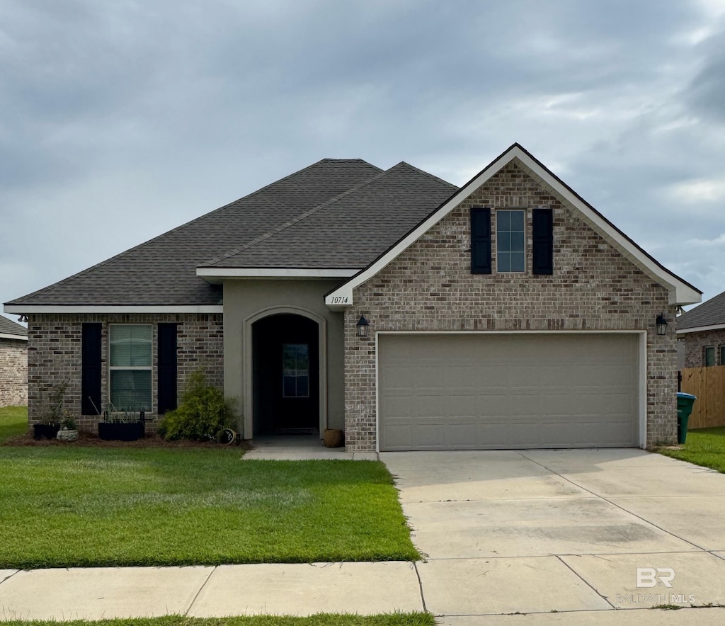 10714 Brodick Loop, Spanish Fort, AL 36527 - traditional home featuring brick siding, driveway, a shingled roof, a front yard, and an attached garage