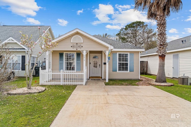 view of front facade with a porch, fence, cooling unit, a front yard, and a shingled roof