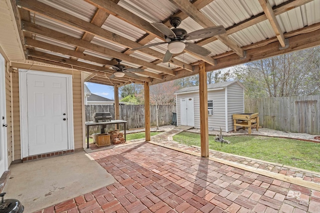 view of patio / terrace with a storage shed, an outdoor structure, a fenced backyard, and ceiling fan