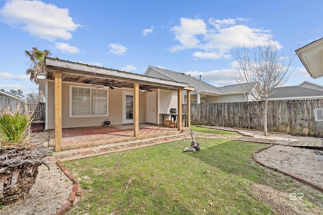 back of property featuring a fenced backyard, a patio area, ceiling fan, and a yard