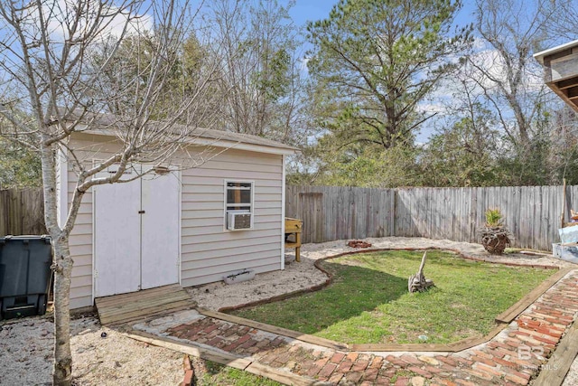 view of yard with an outdoor structure, a fenced backyard, and a shed