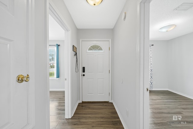 entryway with visible vents, baseboards, and dark wood-style flooring