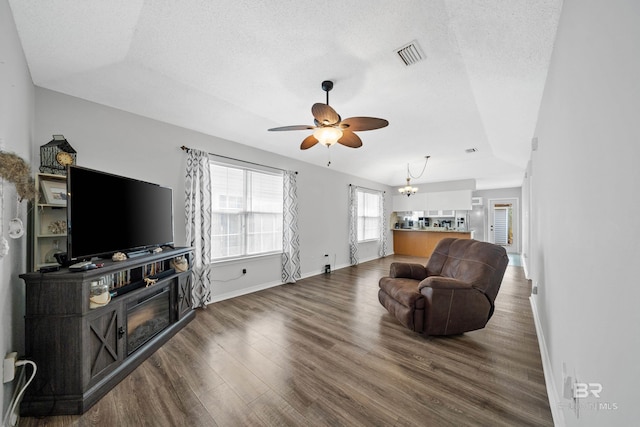 living area featuring visible vents, a textured ceiling, and wood finished floors