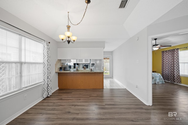 interior space featuring plenty of natural light, appliances with stainless steel finishes, a peninsula, and dark wood finished floors