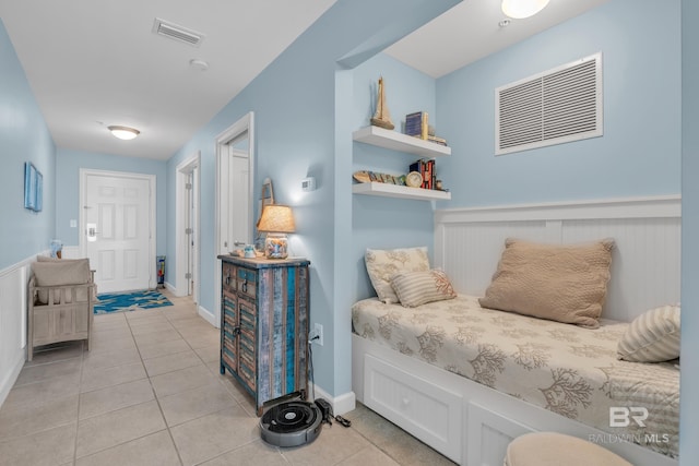453 Dune Dr Unit 305, Gulf Shores, AL 36542 - bedroom with light tile patterned flooring and a wainscoted wall