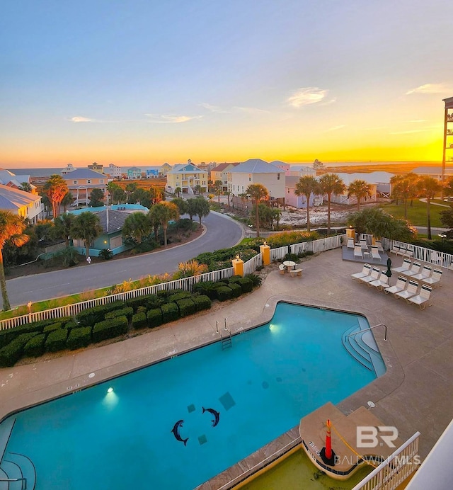 453 Dune Dr Unit 305, Gulf Shores, AL 36542 - pool at dusk featuring a patio, a community pool, and a residential view