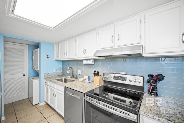 327 E Beach Blvd Unit 7C, Gulf Shores, AL 36542 - kitchen featuring under cabinet range hood, appliances with stainless steel finishes, a sink, stacked washer / dryer, and white cabinets