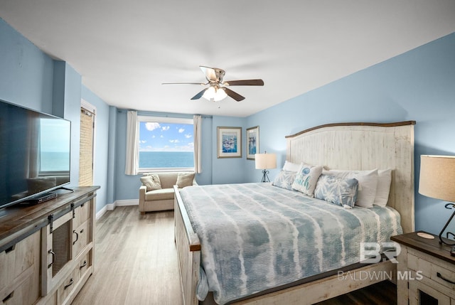 327 E Beach Blvd Unit 7C, Gulf Shores, AL 36542 - bedroom with light wood-type flooring, baseboards, and a ceiling fan