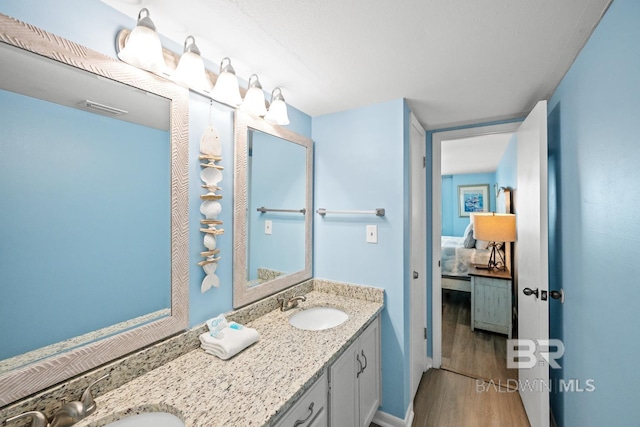 327 E Beach Blvd Unit 7C, Gulf Shores, AL 36542 - full bathroom featuring ensuite bath, wood finished floors, and double vanity