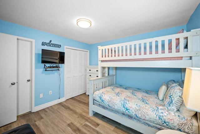 327 E Beach Blvd Unit 7C, Gulf Shores, AL 36542 - bedroom with wood finished floors, baseboards, and a closet