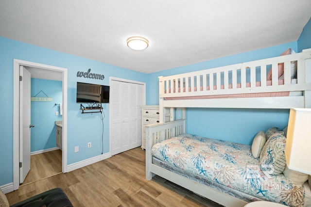 327 E Beach Blvd Unit 7C, Gulf Shores, AL 36542 - bedroom featuring wood finished floors, baseboards, a closet, and connected bathroom