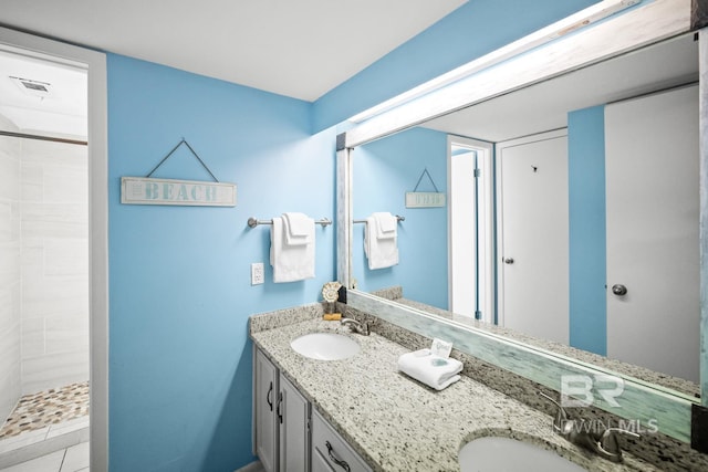 327 E Beach Blvd Unit 7C, Gulf Shores, AL 36542 - bathroom featuring double vanity and a tile shower
