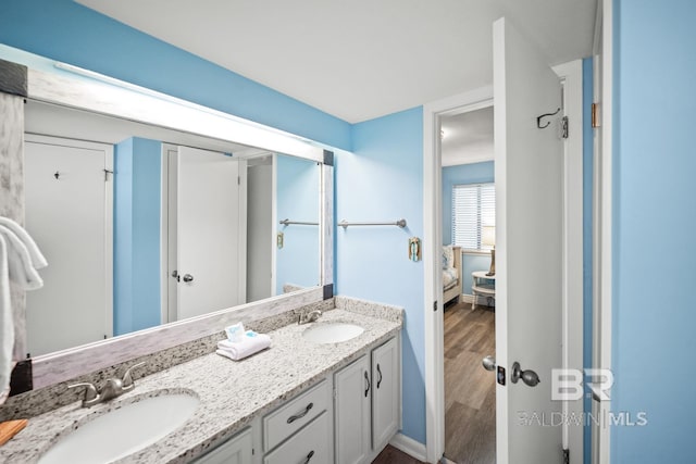 327 E Beach Blvd Unit 7C, Gulf Shores, AL 36542 - ensuite bathroom featuring double vanity, wood finished floors, and baseboards