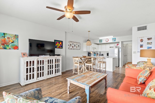 living room featuring ceiling fan and dark hardwood / wood-style flooring