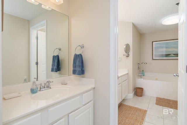 bathroom with a tub to relax in, tile patterned flooring, vanity, and a textured ceiling