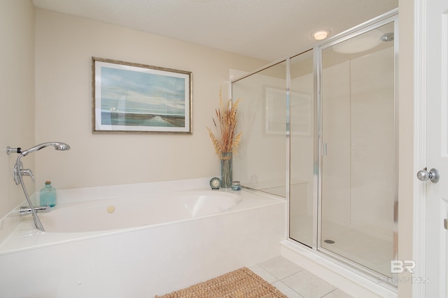 bathroom with tile patterned floors, shower with separate bathtub, and a textured ceiling