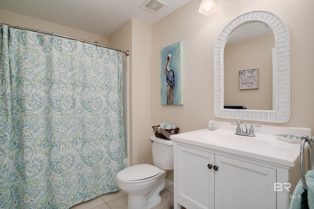 bathroom featuring tile patterned floors, vanity, toilet, and a textured ceiling