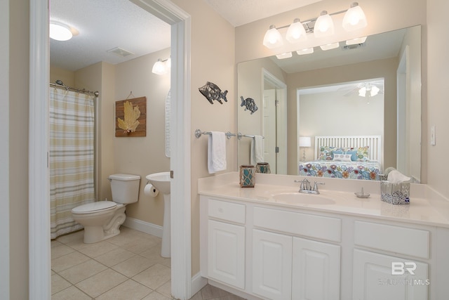 bathroom featuring sink, tile patterned floors, toilet, and a textured ceiling