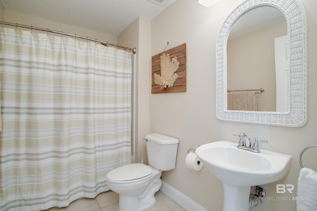 bathroom with sink, tile patterned flooring, a textured ceiling, toilet, and walk in shower