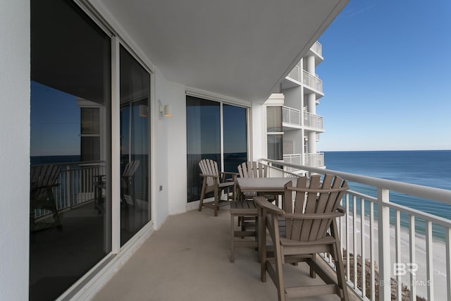 balcony featuring a view of the beach and a water view