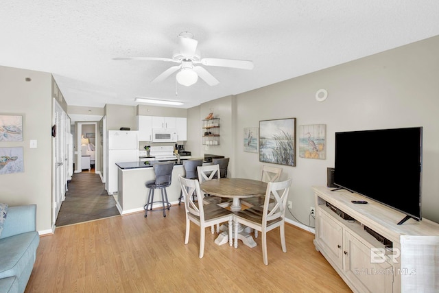 24568 Perdido Beach Blvd Unit 603, Orange Beach, AL 36561 - dining space featuring light wood finished floors, ceiling fan, a textured ceiling, and baseboards