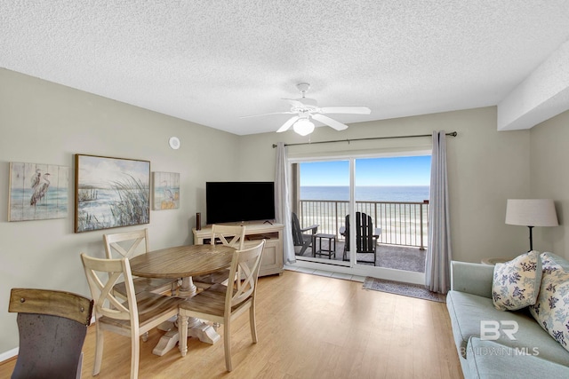 24568 Perdido Beach Blvd Unit 603, Orange Beach, AL 36561 - dining space with light wood-style floors, a ceiling fan, and a textured ceiling