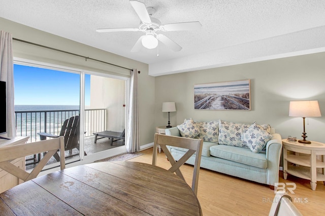 24568 Perdido Beach Blvd Unit 603, Orange Beach, AL 36561 - living area with a textured ceiling, light wood-type flooring, ceiling fan, and a water view