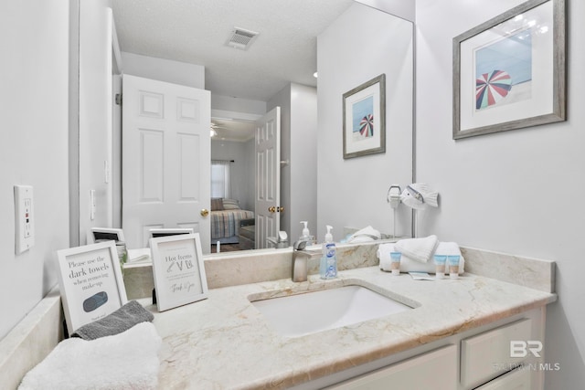 bathroom featuring vanity, a textured ceiling, and ceiling fan