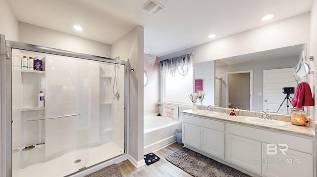 full bathroom with double vanity, a sink, a bath, and a shower stall