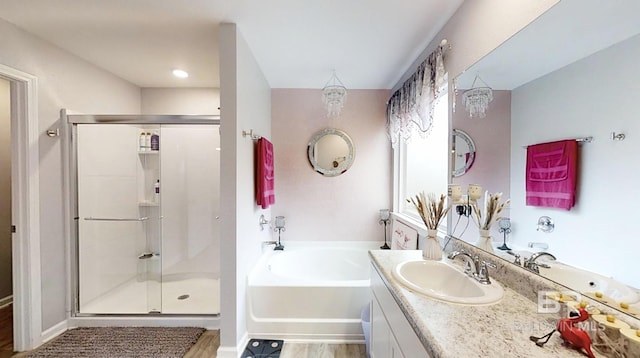 bathroom featuring wood finished floors, a shower stall, vanity, and a bath