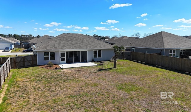 back of property with a sunroom, a fenced backyard, a patio area, and a lawn