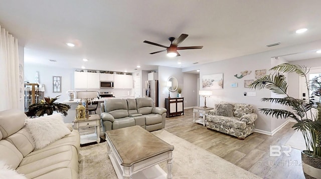 living room with a ceiling fan, recessed lighting, visible vents, and light wood finished floors