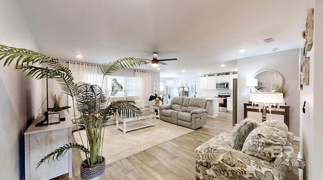 living area with light wood-style floors, ceiling fan, visible vents, and recessed lighting