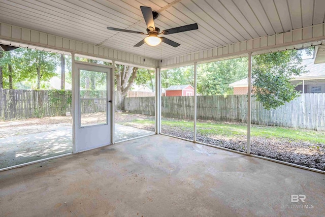 unfurnished sunroom featuring a ceiling fan