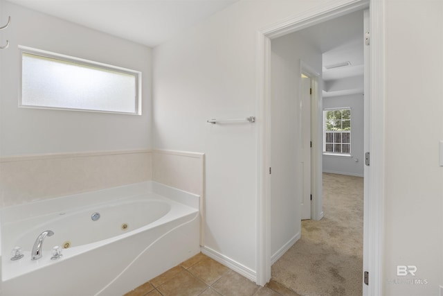 full bathroom with a jetted tub, tile patterned flooring, and baseboards