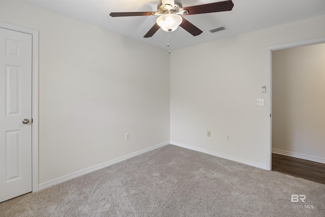 empty room with carpet floors, visible vents, and baseboards