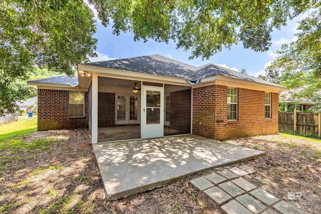 rear view of property featuring french doors, brick siding, a patio, a ceiling fan, and fence