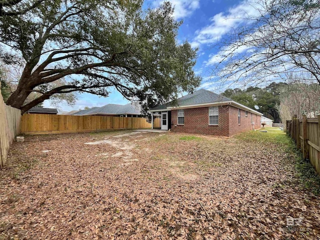 exterior space with a fenced backyard and brick siding