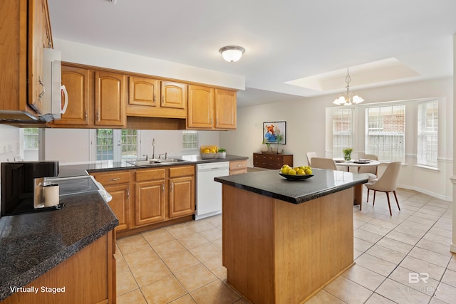 kitchen with a center island, light tile patterned floors, dark countertops, a sink, and white appliances