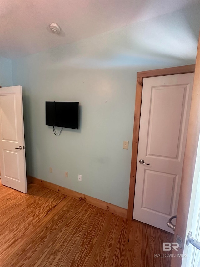 unfurnished room with wood-type flooring