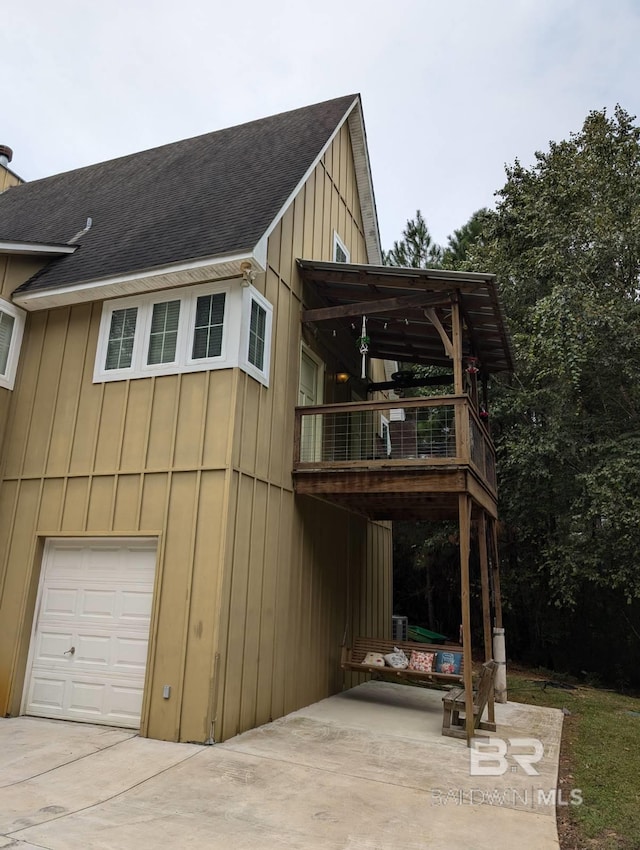 view of side of home featuring a balcony and a garage