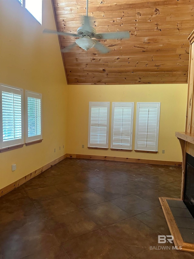 unfurnished living room featuring ceiling fan, dark tile patterned floors, high vaulted ceiling, and wooden ceiling