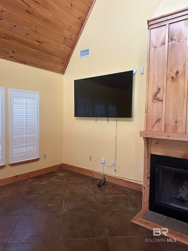 unfurnished living room featuring lofted ceiling, dark tile patterned flooring, and wooden ceiling